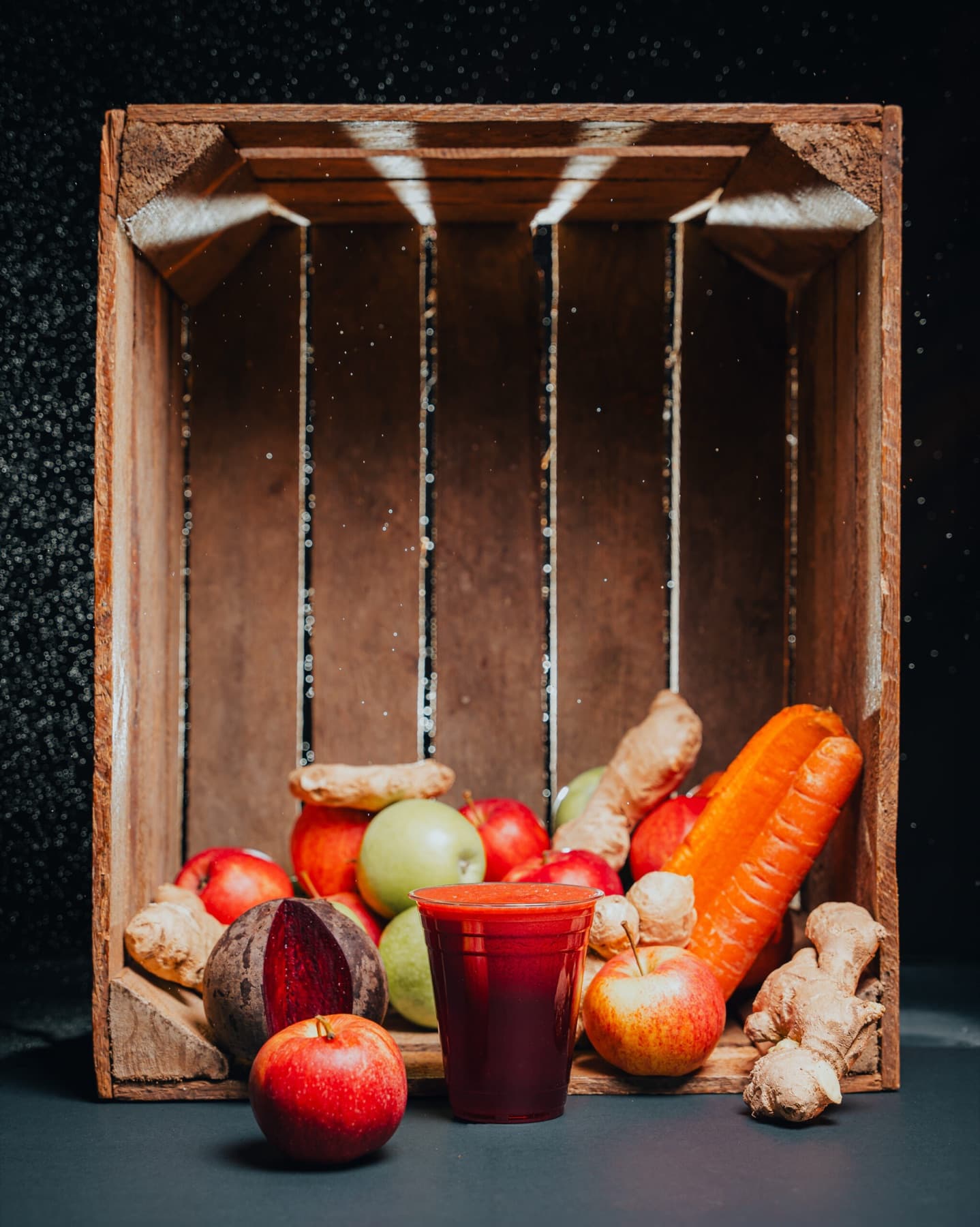 A clear cup of bright Samba juice against a near-black studio background.